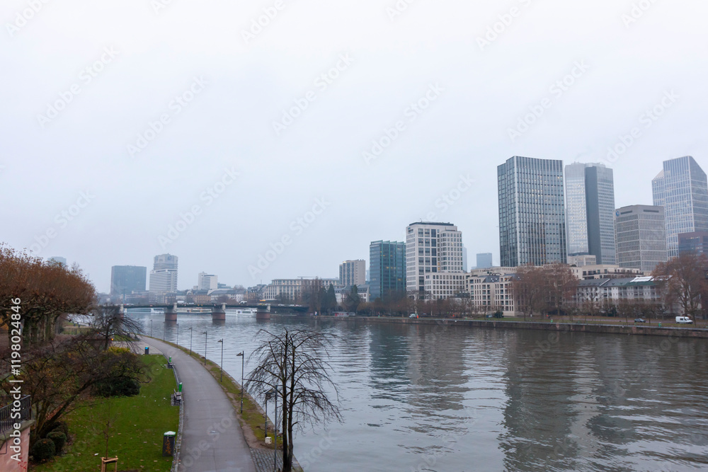 Fototapeta premium Panoramic view of Frankfurt am Main from the Eiserner Steg (Iron Bridge) on a cloudy day