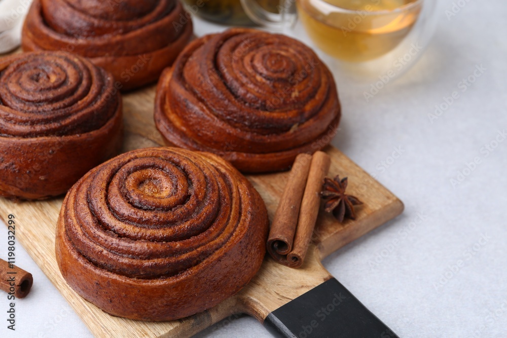 Fototapeta premium Delicious cinnamon roll buns on light table, closeup