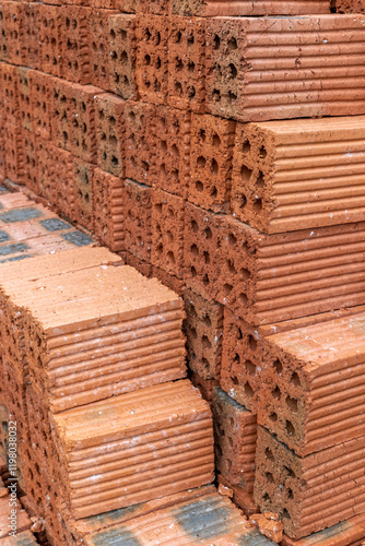 Stacked red clay bricks with grooved texture for construction projects photo