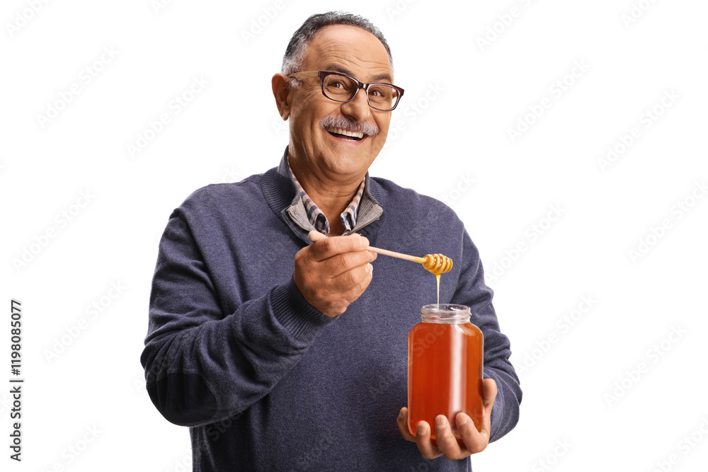 Fototapeta premium Elderly man trying honey from a jar