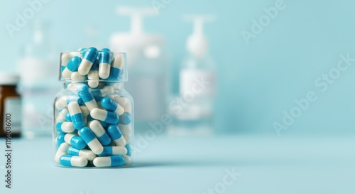 Clear jar of blue and white capsules on light blue background photo