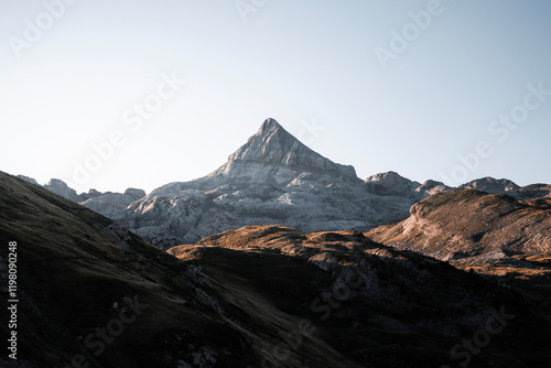 The iconic peak of Auñamendi rises under the first rays of sunlight in the Pyrenees. photo