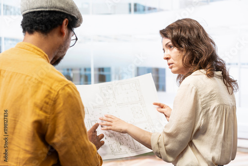 Real estate agent and her client meeting on an office hunt inside modern building, touring potential property and discussing strategic planning for investment and leasing contract. photo