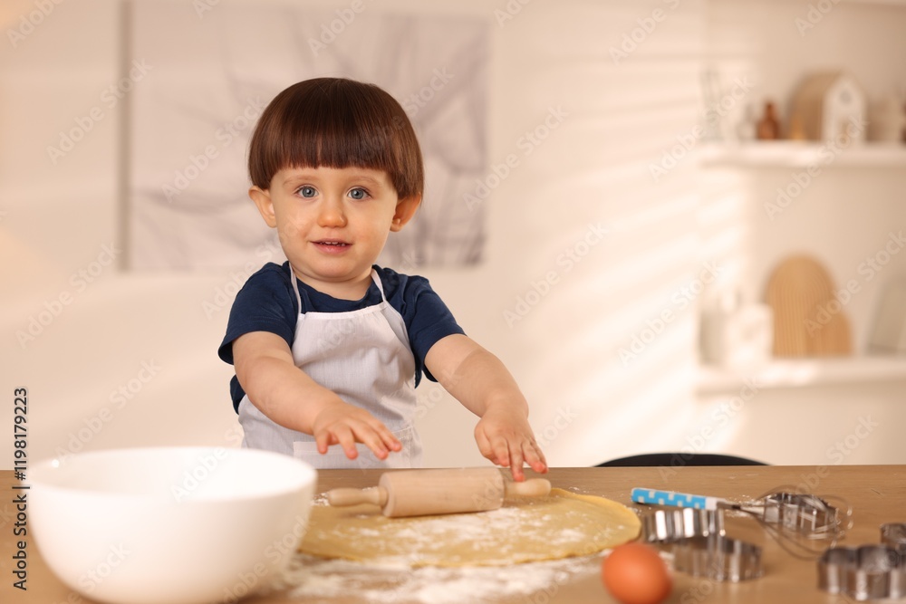 Cute little boy shaping dough with rolling pin at table indoors Cute little boy shaping dough with rolling pin at table indoors