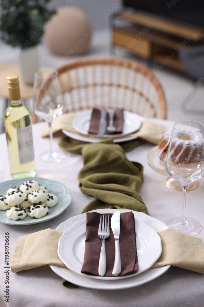Fototapeta premium Festive table setting with dishware, cutlery, glasses, desserts and wine indoors