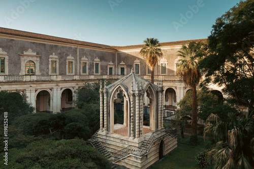 Chiostro dei Marmi with La Caffeaus, designed by architect Musumeci, graces the garden of Monastero dei Benedettini di San Nicolò l'Arena, Catania. A serene fusion of history, art, and nature.
