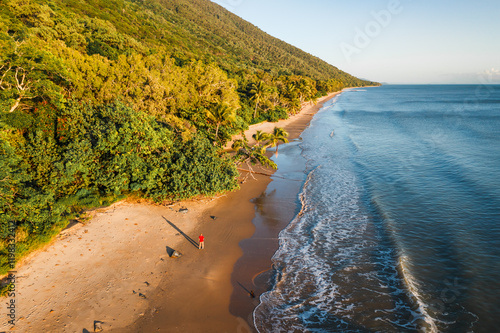 Man standing at Ellis beach at sunrise, Cairns, Australia