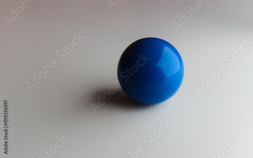 close-up of a smooth blue hard ball with shadow isolated on a white backdrop business metaphor graphic element with space for copy. business recreation activities concept leadership sports backdrop photo