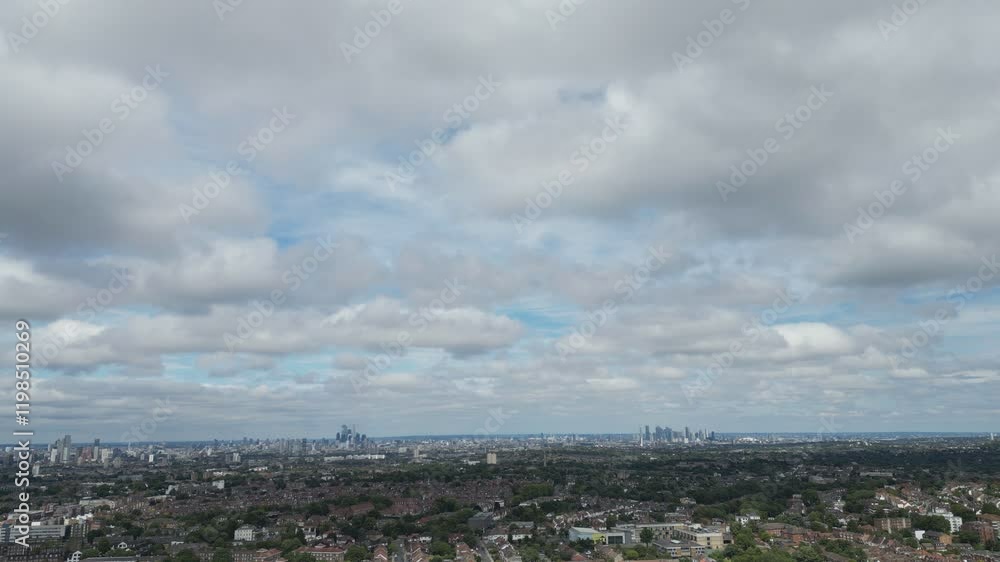 Bird’s eye drone view of expansive cityscape with distant skyline under a partly cloudy sky. Bird’s eye drone view of expansive cityscape with distant skyline under a partly cloudy sky.