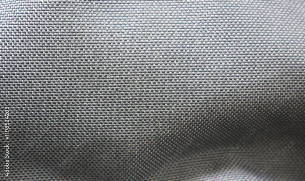 A close-up of a smooth, gray fabric with a tightly woven pattern. The material has a glossy finish and is likely used for outdoor gear such as jackets or backpacks due to its durability A close-up of a smooth, gray fabric with a tightly woven pattern. The material has a glossy finish and is likely used for outdoor gear such as jackets or backpacks due to its durability