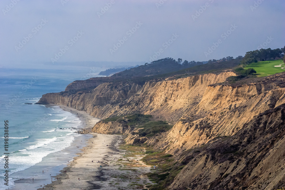 A rocky shoreline with a beach and a cliff A rocky shoreline with a beach and a cliff