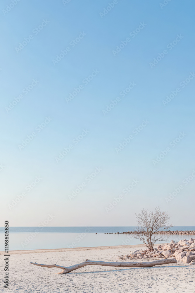 Tranquil beach landscape with calm waters and distant shoreline under clear sky Tranquil beach landscape with calm waters and distant shoreline under clear sky