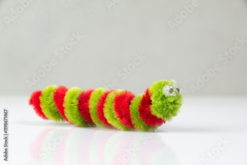 Close-up of Red-green striped caterpillar, children's toys, pipe cleaners photo