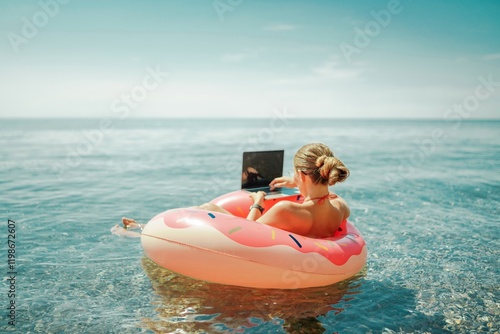 Woman laptop sea. Freelancer woman in sunglases floating on an inflatable big pink donut with a laptop in the sea. People summer vacation rest lifestyle concept photo