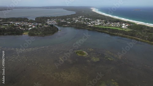 View From Above Of Budgewoi Lake, Lake Munmorah, And Tasman Sea In New South Wales, Australia. aerial sideways shot photo