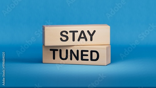 Stay Tuned symbol. Wooden blocks with words Stay Tuned Business and Stay Tuned concept. Wooden cube blocks. Copy space.3D rendering on blue background. photo