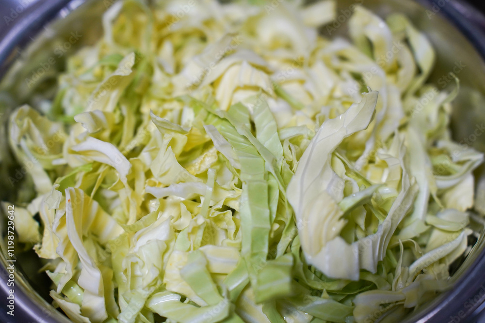 sliced fresh green cabbage in a iron bowl. Sliced fresh green cabbage.
