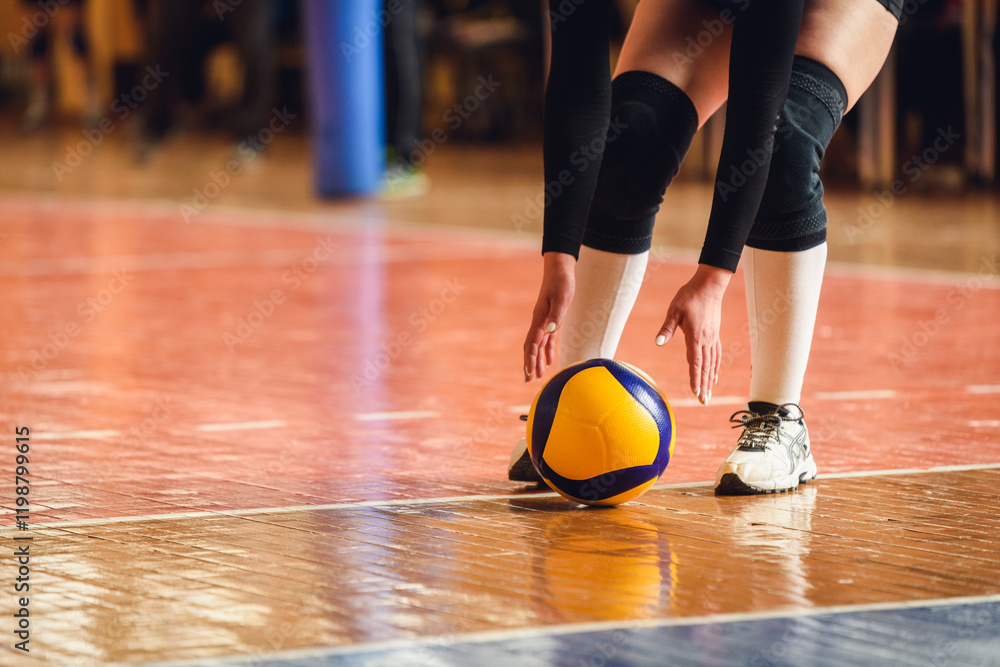 Naklejka premium Volleyball Player Reaching for Yellow Ball on Indoor Court — Moment of Action in Team Game