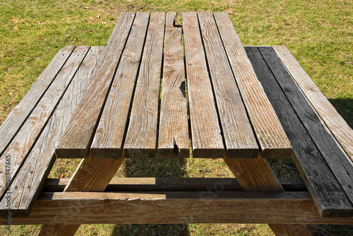 EMPTY WOODEN PICNIC TABLE WITH BENCHES on a green meadow in a pu photo