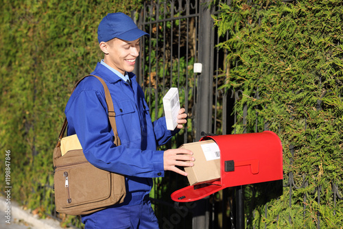 Fotografi Postman putting parcel into mail box outdoors