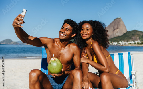 Cheerful couple taking a selfie at the beach with Sugarloaf Mountain in the background photo