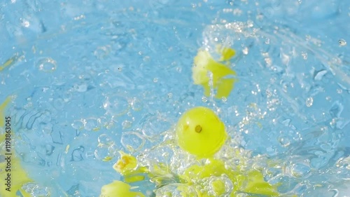 Fresh organic green grapes splashing into water in slow motion 300fps