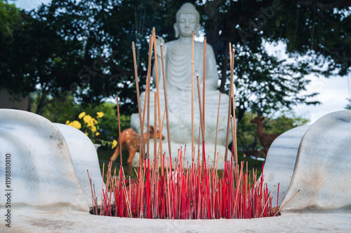 a bowl of incense on the background of a white Buddha in foliage at the Da Nang pagoda Linh ung photo