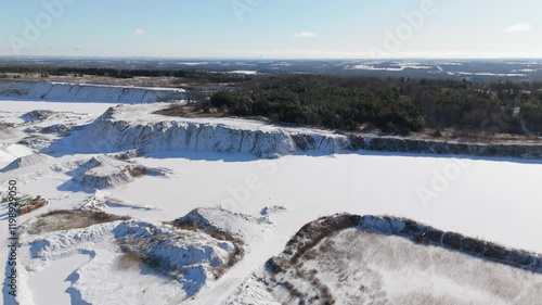 Wide aerial of snowy stone quarry and forest in winter in rural Canada photo