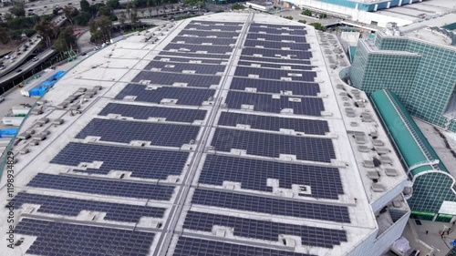 Roof of Los Angeles Convention Center, array of large solar panel for renewable energy in downtown, aerial rising photo