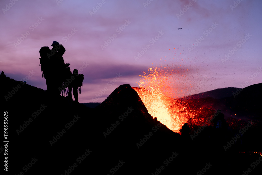 black silhouettes of people watching an eruption in Iceland