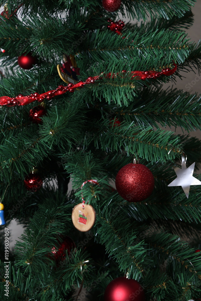 Obraz premium Christmas tree with red baubles and tinsel, festive holiday decoration close up