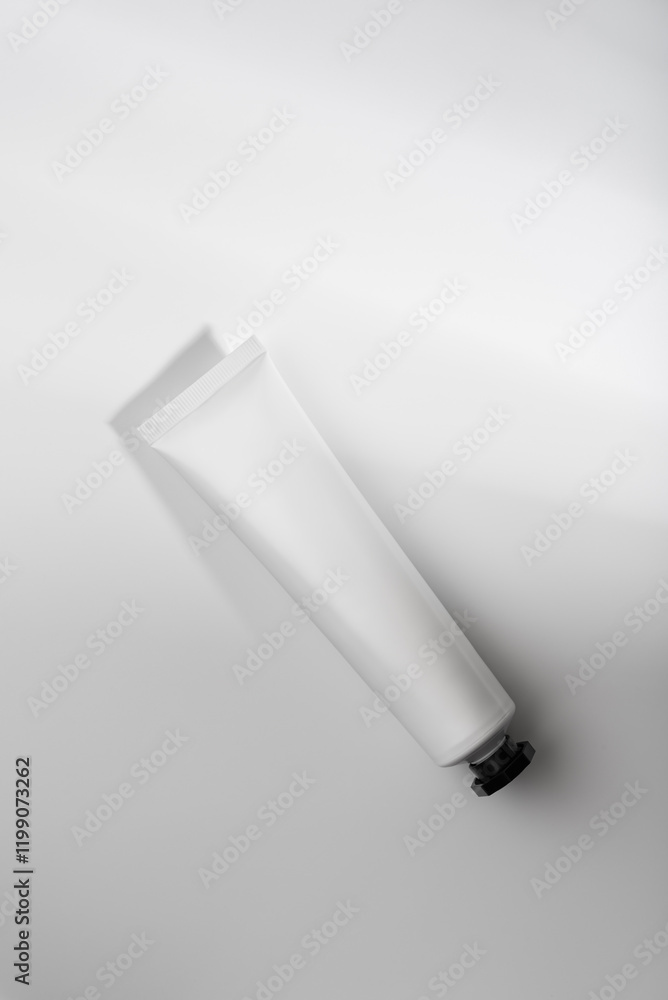 Minimalistic composition of white cosmetic tube with black cap Minimalistic composition of white cosmetic tube with black cap