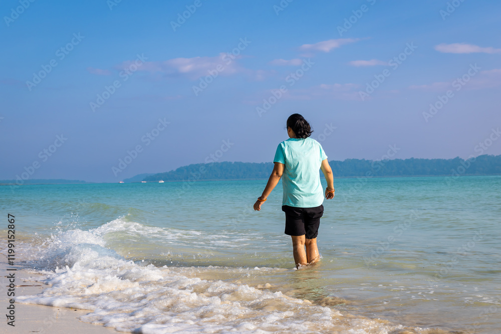 Isolated Girl relaxing at pristine Sandy Beach Shore with rolling waves in Morning Isolated Girl relaxing at pristine Sandy Beach Shore with rolling waves in Morning