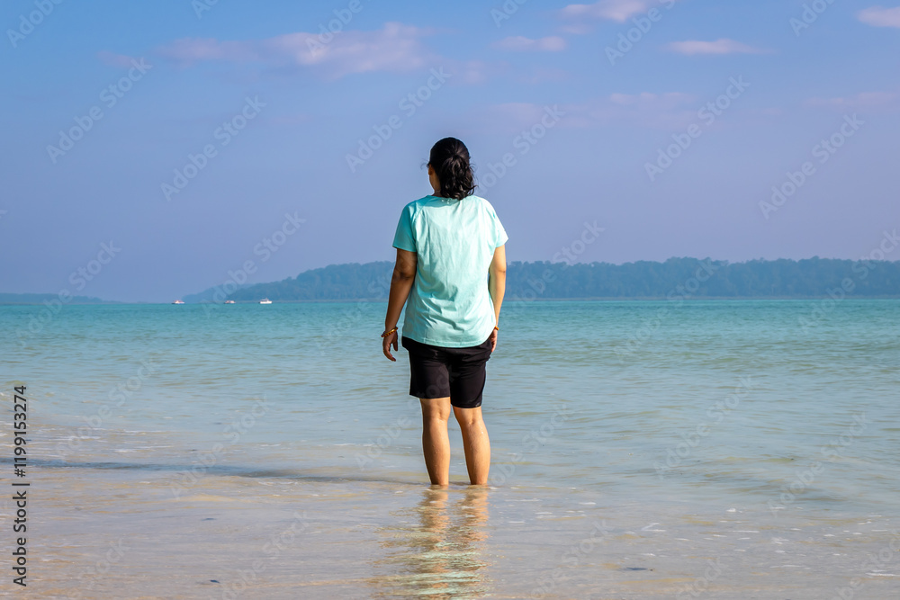 Isolated Girl relaxing at pristine Sandy Beach Shore with rolling waves in Morning Isolated Girl relaxing at pristine Sandy Beach Shore with rolling waves in Morning