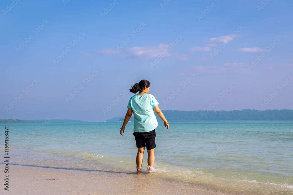 Isolated Girl relaxing at pristine Sandy Beach Shore with rolling waves in Morning Isolated Girl relaxing at pristine Sandy Beach Shore with rolling waves in Morning