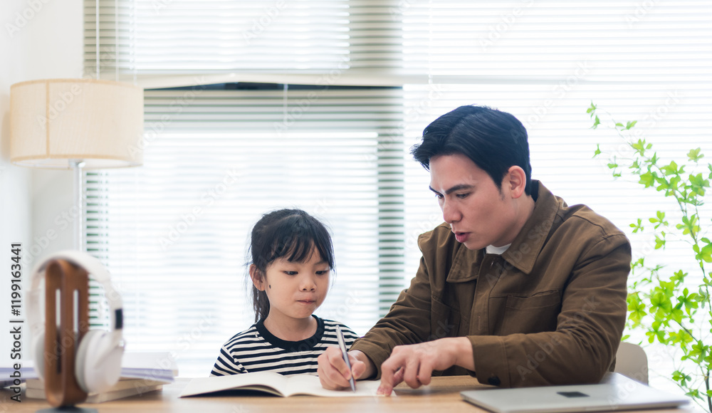 Fototapeta premium Young Asian father and daughter studying together