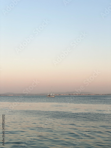 Serene seascape with a sailboat on calm waters during sunset