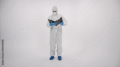 A scientist in PPE verifying a medical record and exiting the white background