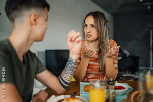 Lesbian couple having breakfast and discussing at home photo