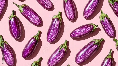 Purple eggplants arranged on pink background. photo