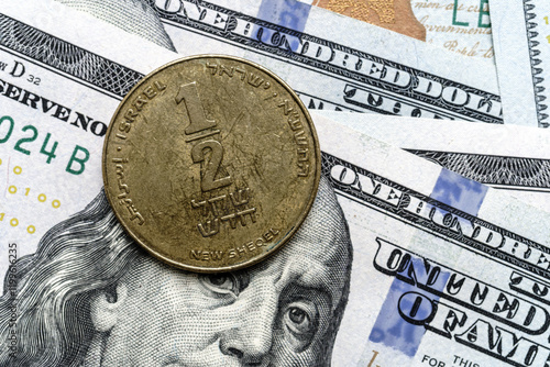 Close-up of a Israel shekel coin on US 100 dollar bills in focus. photo