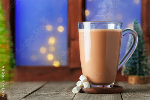 hot chocolate or cocoa with marshmallows in glass cup on table with window photo