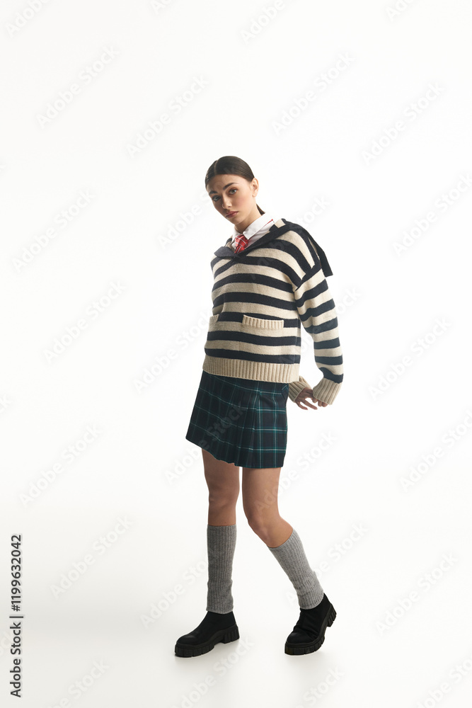 A young woman stands confidently, showcasing her emotional expression, dressed in a chic outfit. A young woman stands confidently, showcasing her emotional expression, dressed in a chic outfit.