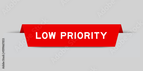 Red color inserted label with word low priority on gray background