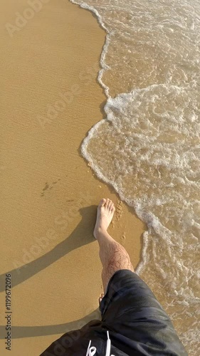 Male leg from above walking at the beach