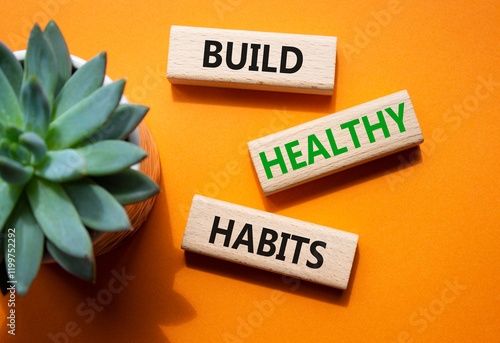 Healthy habits symbol. Concept word Build Healthy habits on wooden blocks. Beautiful orange background with succulent plant. Healthy lifestyle and Healthy habits concept. Copy space