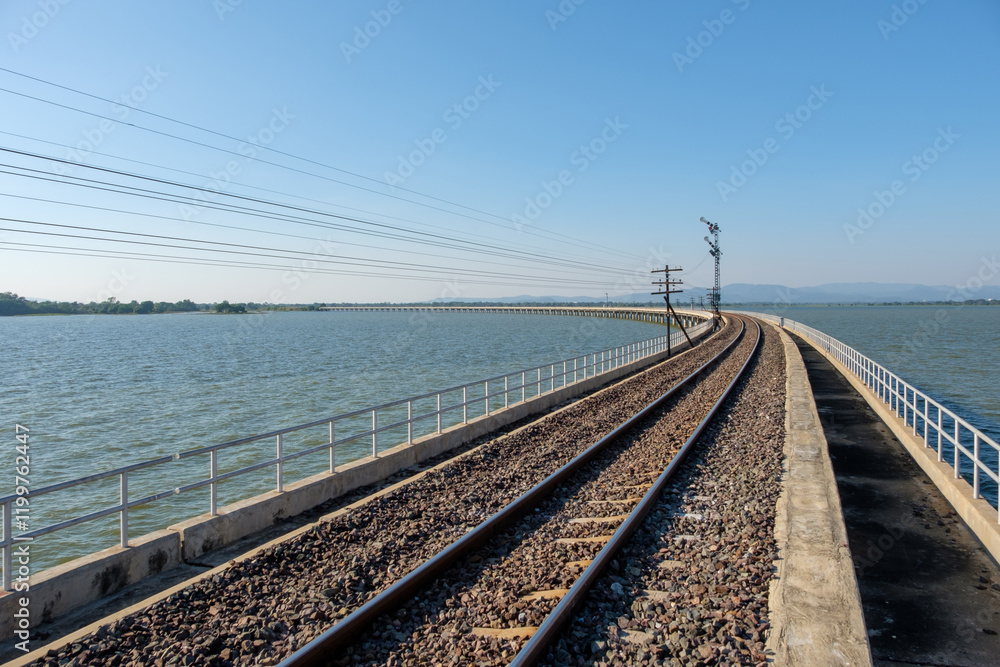 Railway Bridge Over Reservoir with Signal Tower on a Sunny Day.