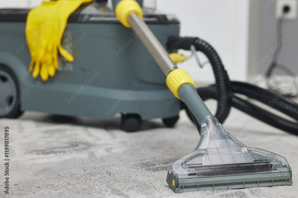 Professional wet and dry vacuum cleaner set up on a gray carpet, showing a scene of carpet cleaning process. The equipment is ready for thorough cleaning, highlighting cleanliness and maintenance. Professional wet and dry vacuum cleaner set up on a gray carpet, showing a scene of carpet cleaning process. The equipment is ready for thorough cleaning, highlighting cleanliness and maintenance.