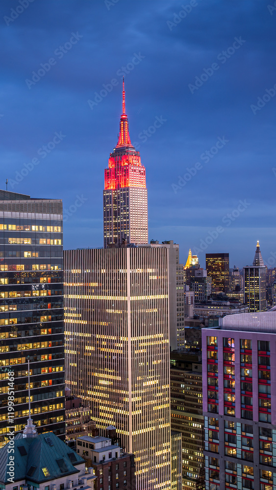 Fototapeta premium A nighttime view of Manhattan downtown in the New York City showcasing illuminated skyscrapers, set against a deep blue sky.