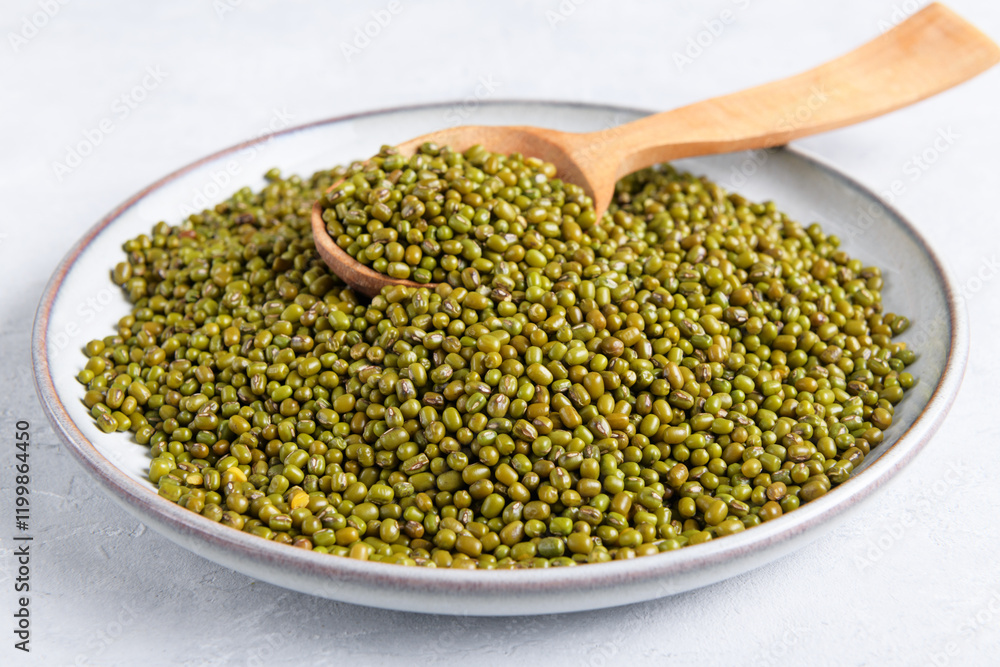 Green mung beans on ceramic plate on light gray table background. Healthy plant-based protein, healthy cooking ingredient for vegan recipes and vegetarian diets, close up Green mung beans on ceramic plate on light gray table background. Healthy plant-based protein, healthy cooking ingredient for vegan recipes and vegetarian diets, close up